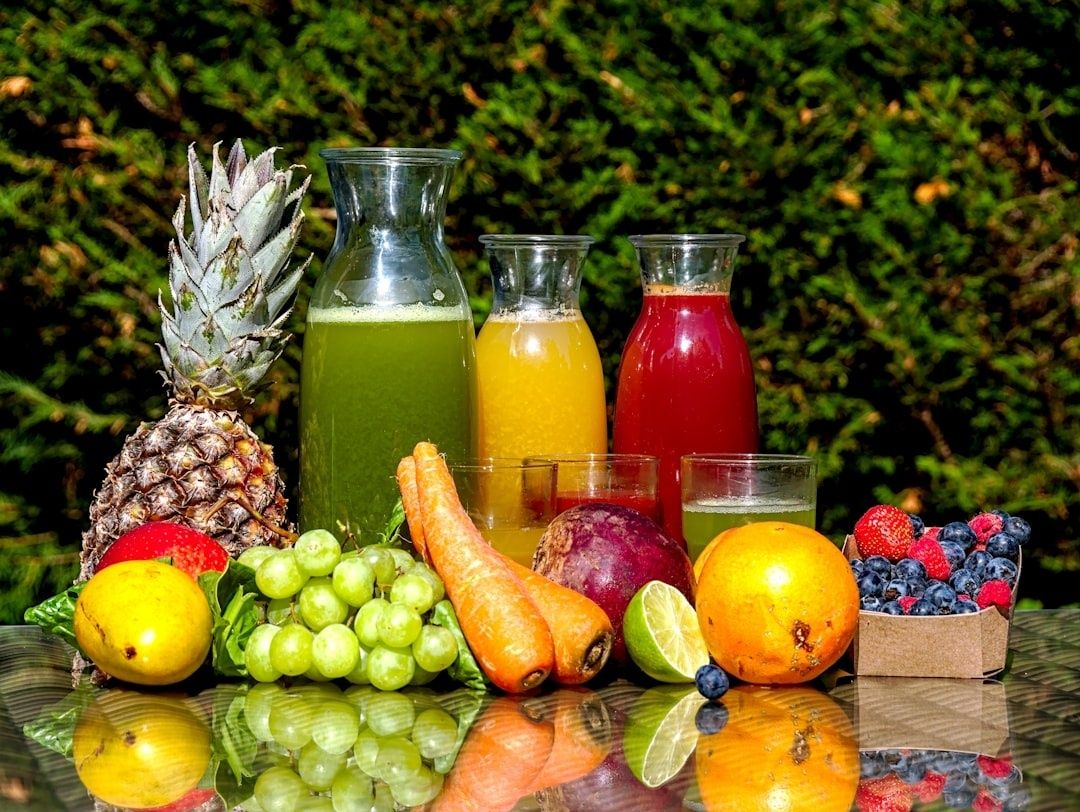 Färskpressade juicer med frukt och grönsaker i solljus