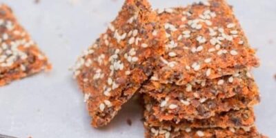 Knapriga frökex med orangefärgad grönsakspulpa på ett fat