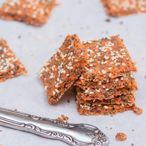 Knapriga frökex med orangefärgad grönsakspulpa på ett fat